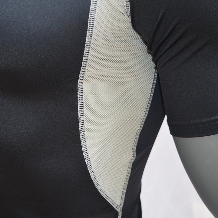 Mesh side panel and underarm of a black short-sleeve rash guard, close-up