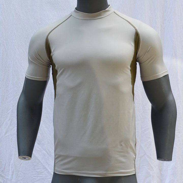 Beige short-sleeve rash guard with olive mesh side panels on a mannequin, front view