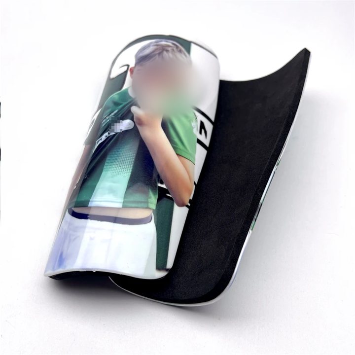 Photo-printed full-size shin guard shown with its foam-lined underside