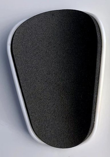 Foam-lined back of a small-format shin guard with a white shell edge