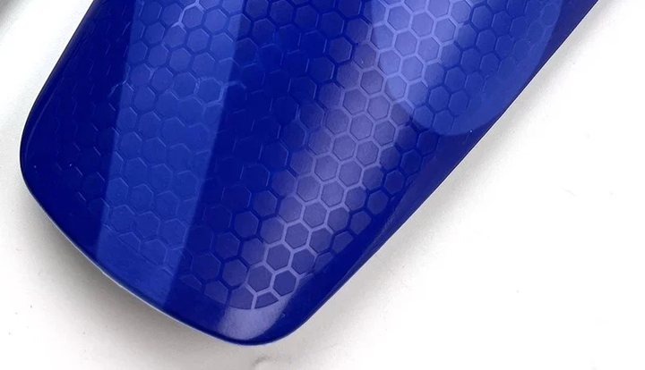 Close-up of the honeycomb-textured surface of a blue full-size shin guard