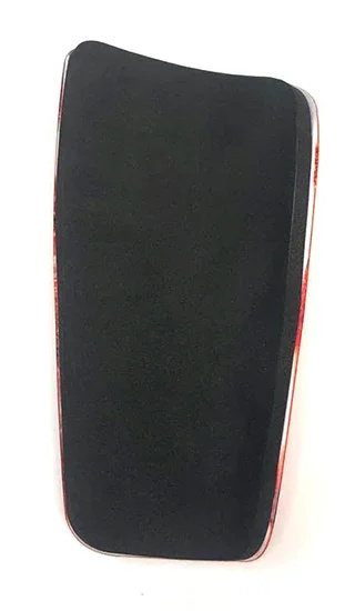 Foam-lined back of a full-size shin guard with a red shell edge