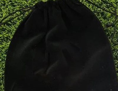 Black drawstring bag on artificial turf