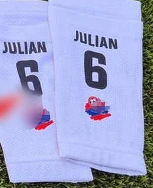 Pair of white shin guard sleeve socks printed 'JULIAN 6' on turf